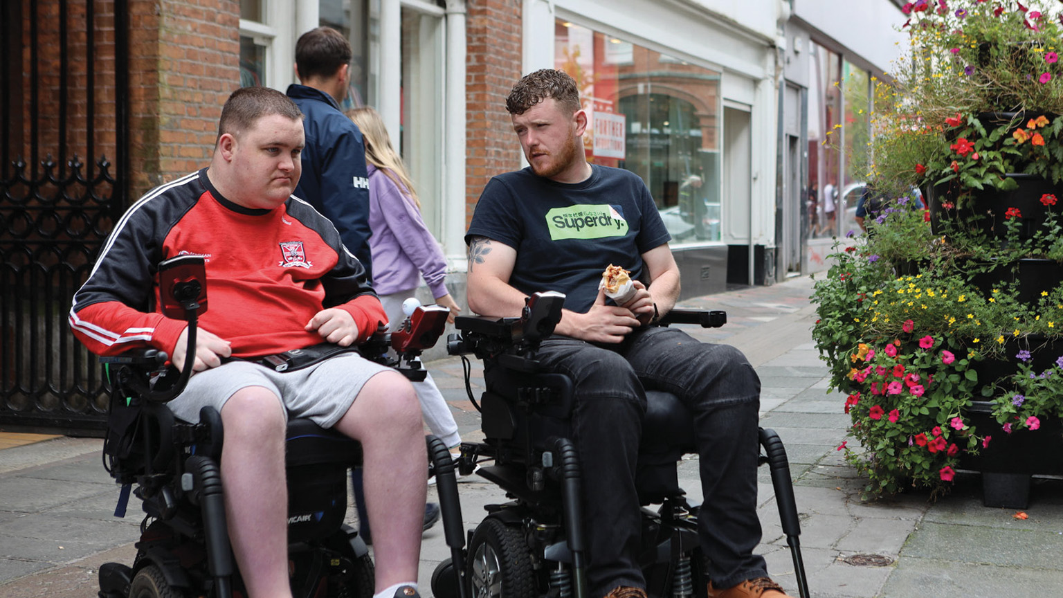 PJ and Jack sitting outside in their wheelchairs
