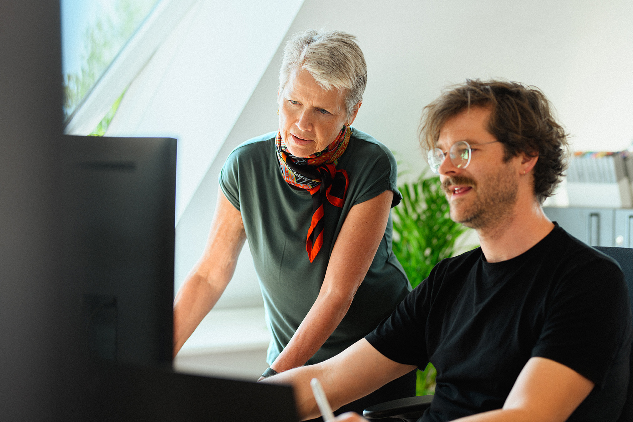 Two Qufora employees looking at the computer