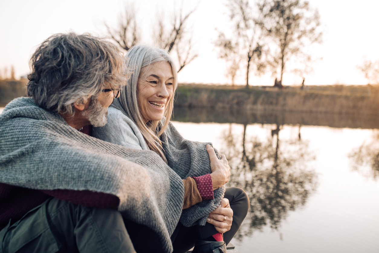 Senior couple relaxing and talking by the river