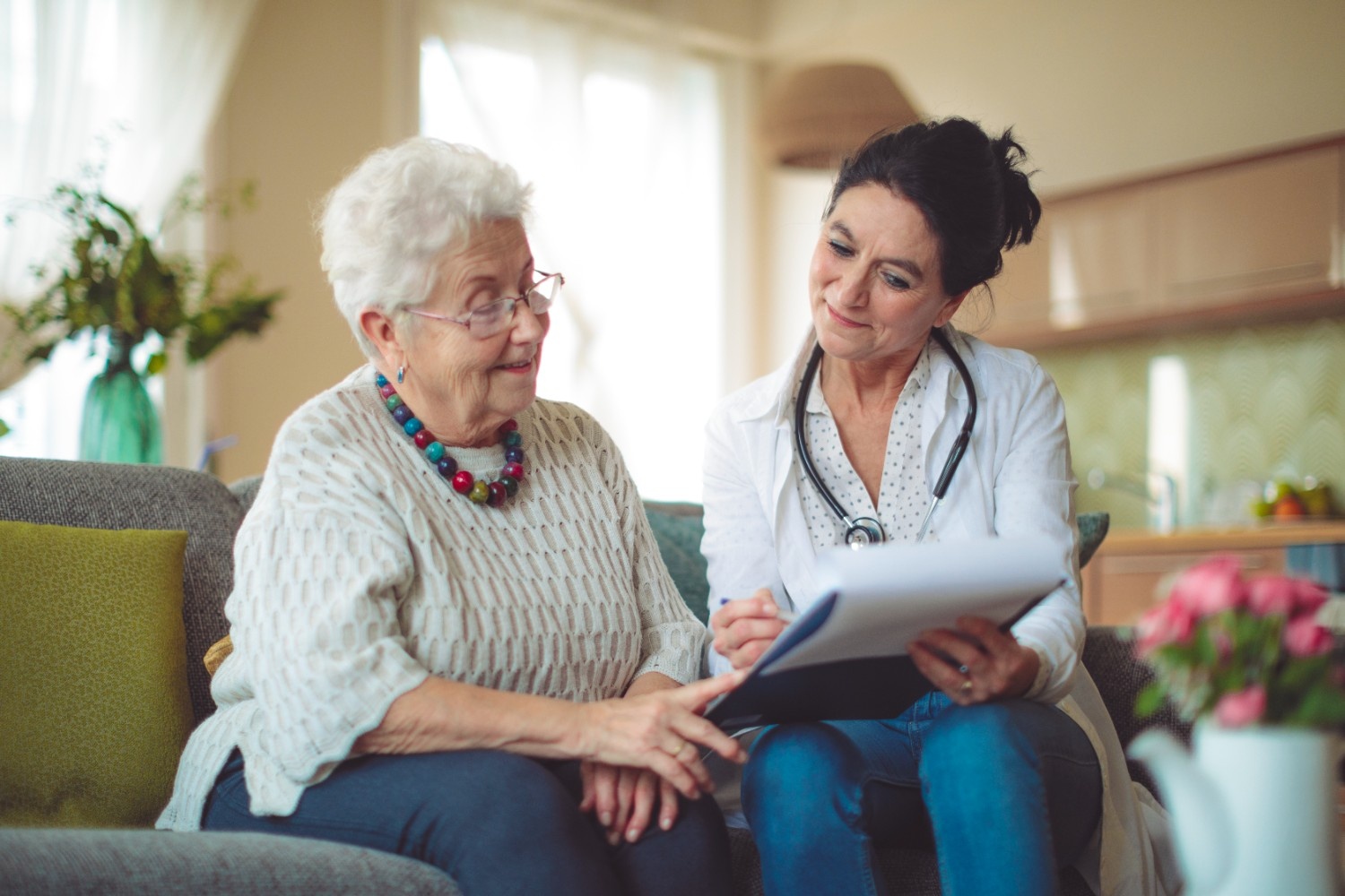 A healthcare professional sitting with a patient looking at chart with positive results, Qufora